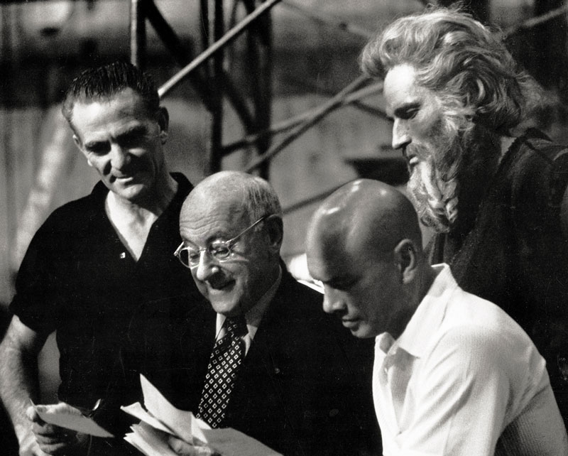 DeMille conferring with associate producer Henry Wilcoxon and stars Yul Brynner, Charlton Heston