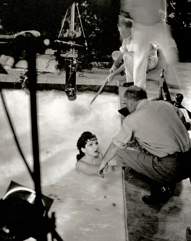 An early microphone hovers over Claudette Colbert and DeMille on the set of The Sign of the Cross (1932)